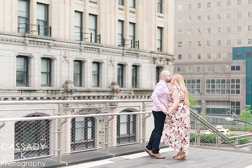 Engaged couple kissing with NYC buildings behind them during a Brookfield Place Engagement Session