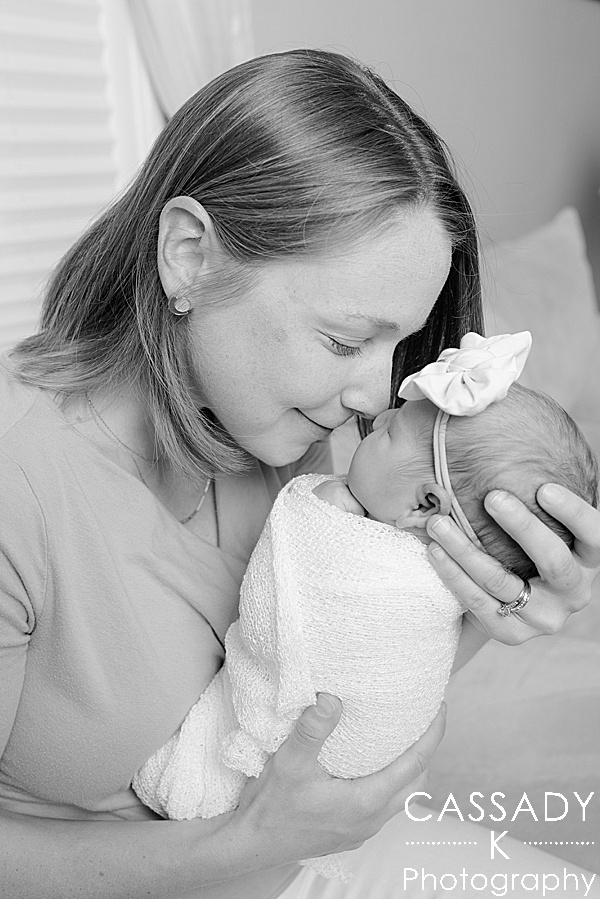 Mommy snuggles noses with baby girl during a PA Family Newborn Session at home in Lansdale