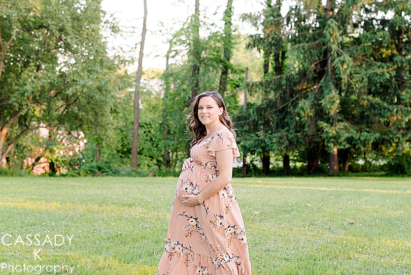 Pregnant Mommy walks through a field in a flowing maxi dress during a Pittsburgh Maternity Session