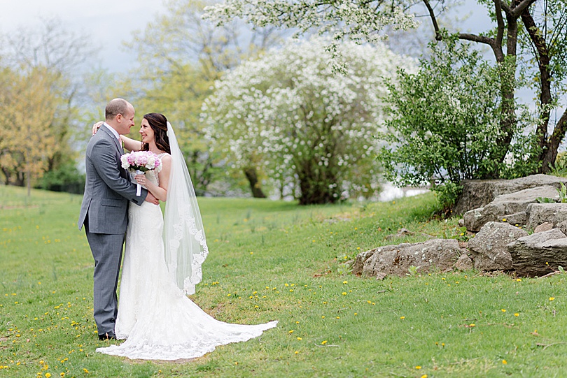 Bride and Groom portrait with flowering trees and green grass before their Jewish Spring Glen Island Wedding in New Rochelle
