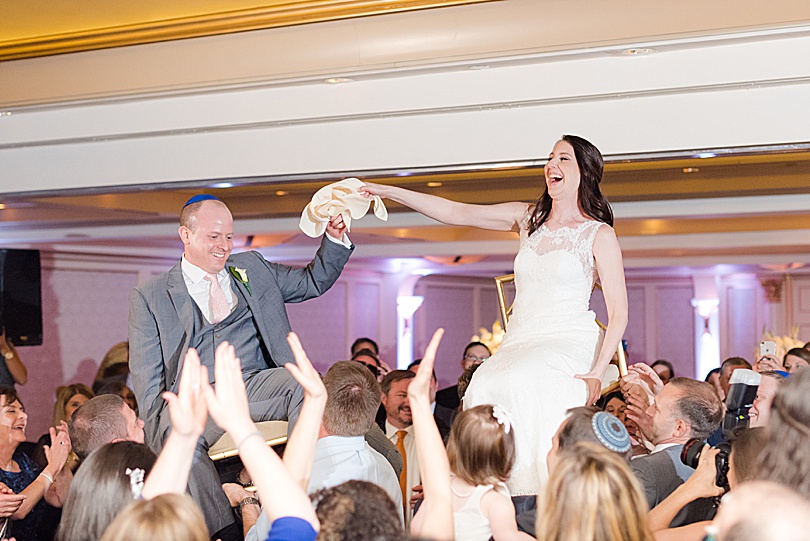 Bride and Groom laugh during The Hora, the chair dance at a Spring Glen Island Wedding Jewish Reception in New Rochelle