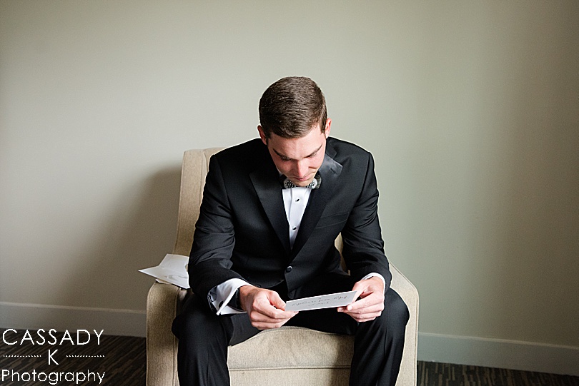 Groom reading a card from the bride before a Small Ninety Acres Wedding in Natirar of Peapack, NJ