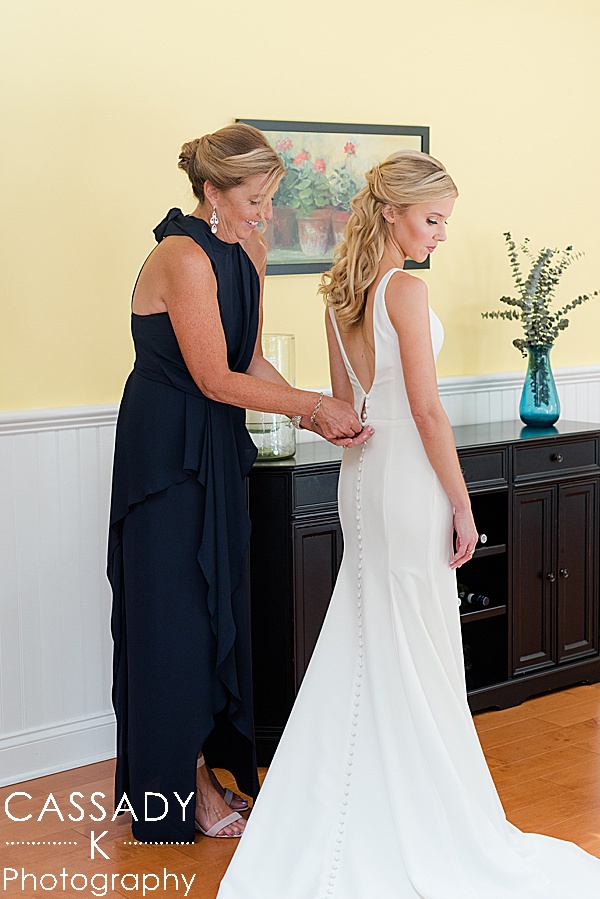 Mother helps daughter into her Sarah Seven bridal dress for a Small Ninety Acres Wedding in Natirar of Peapack, NJ