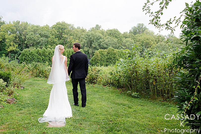 Bride and Groom walk in grass during a Small Ninety Acres Wedding in Natirar of Peapack, NJ