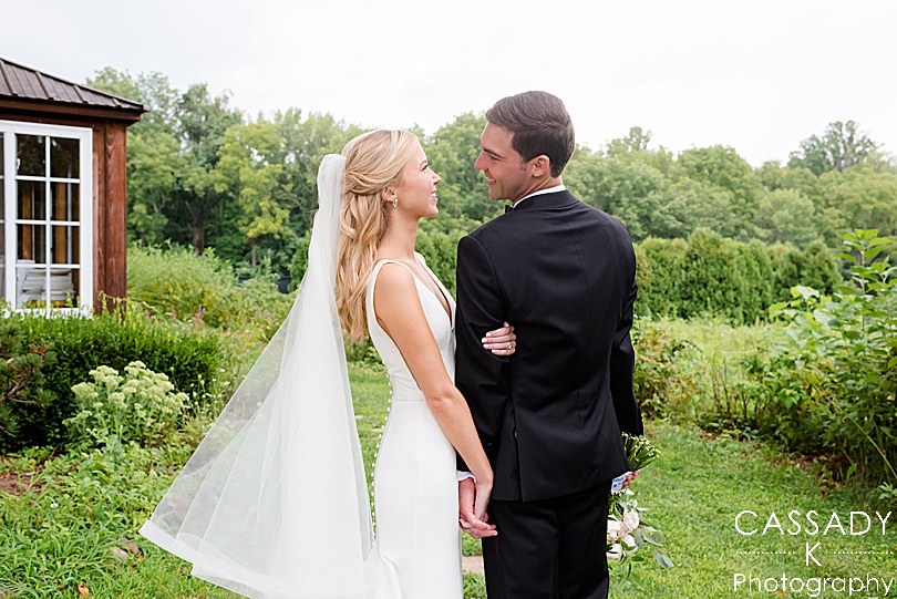 Bride and Groom look at each other in a garden during a Small Ninety Acres Wedding in Natirar of Peapack, NJ