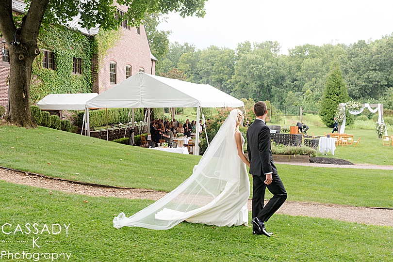 Bride and Groom down path to an outside tented reception during a Small Ninety Acres Wedding in Natirar of Peapack, NJ