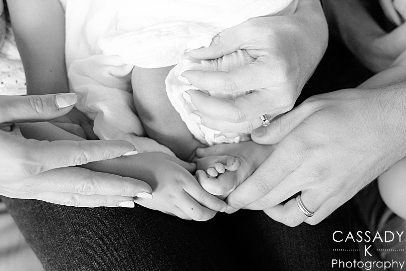 Parents and big brothers hold baby boy's feet at home Williamsport Newborn Session in PA
