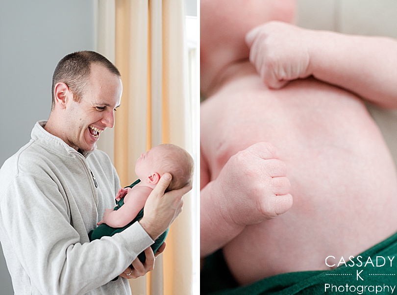 Father excitedly looks at his son wrapped in a forest green swaddle during an at home Bedford newborn session in NY