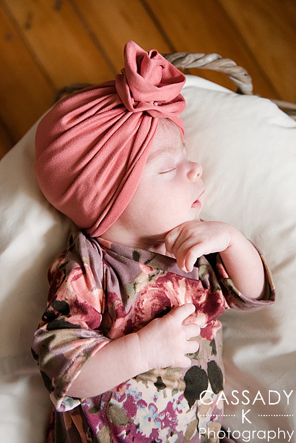 Infant girl wearing her floral coming home outfit with a pink baby turban during an at home Pittsburgh newborn session
