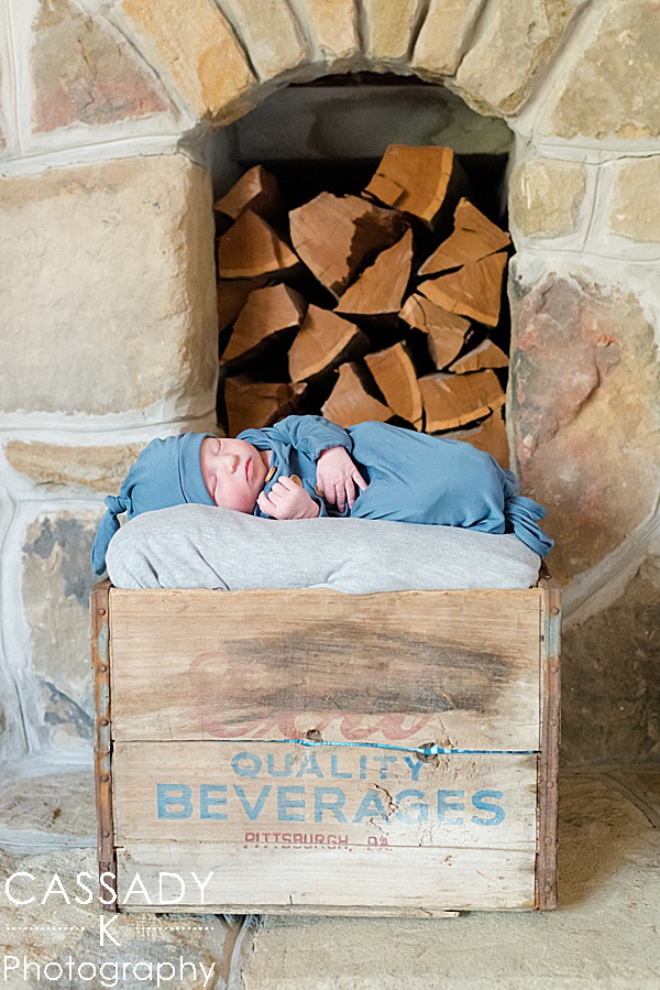 Baby in a blue knotted gown and hat in a wooden box during a newborn session in Pittsburgh, PA for a 2020 photography review