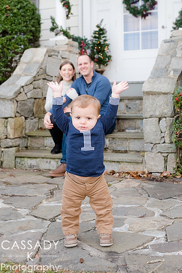 Happy one year old boy walks outside for his at home first birthday pictures in Bedford, NY by Cassady K Photography