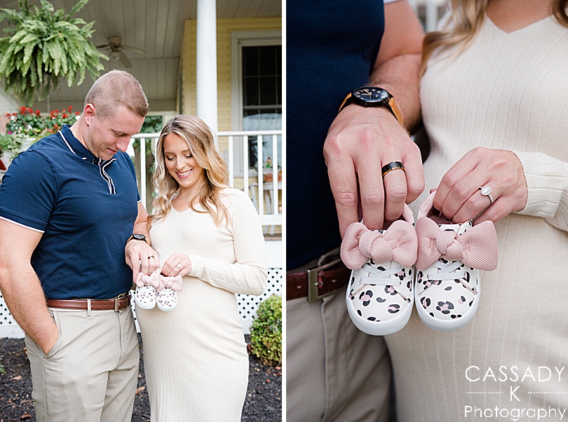 Mom and Dad hold leopard print baby shoes with pink bows during their at home Sewickley Maternity session by a Pittsburgh Family Photographer