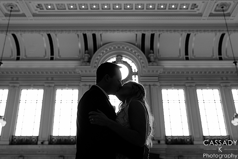 Black and white silhouette image of bride and groom kissing in Hoboken Terminal before Antique Loft Hoboken Wedding