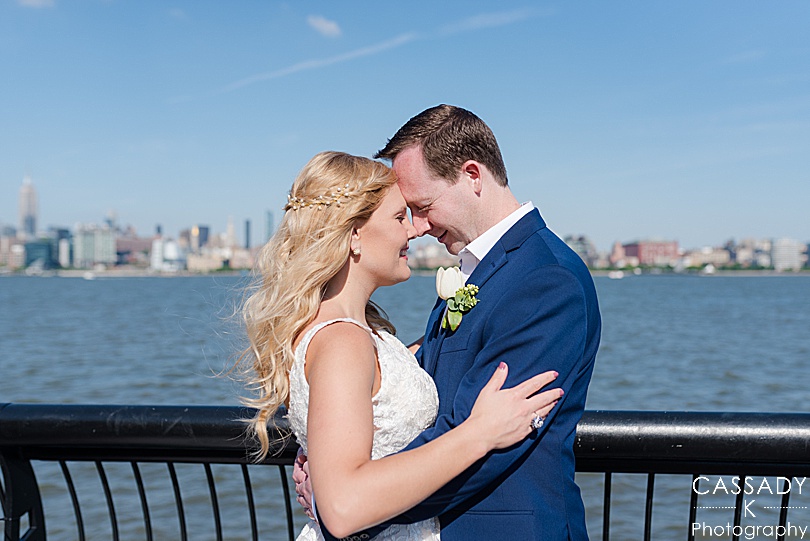 Bride and groom looking at each other with NYC skyline in background before their Antique Loft Hoboken Wedding