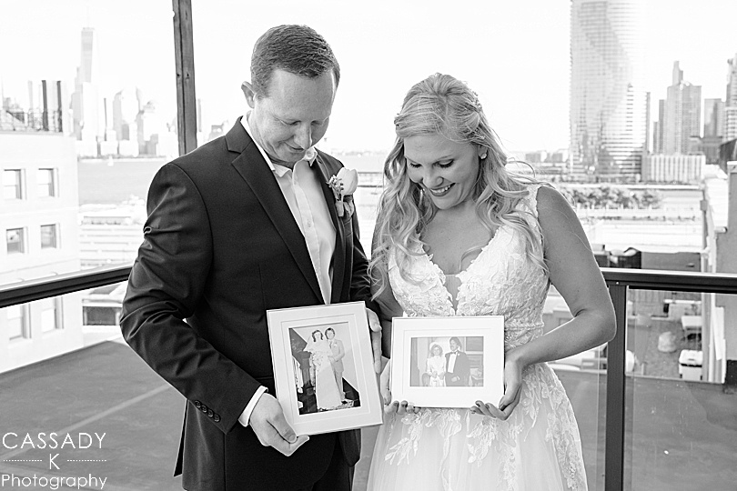 Bride and Groom hold framed pictures of their parents' wedding portraits during their Antique Loft Hoboken Wedding