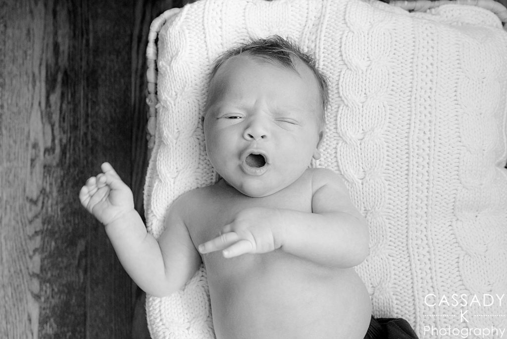 Black and white picture of baby boy yawning during a Bedford home newborn 
