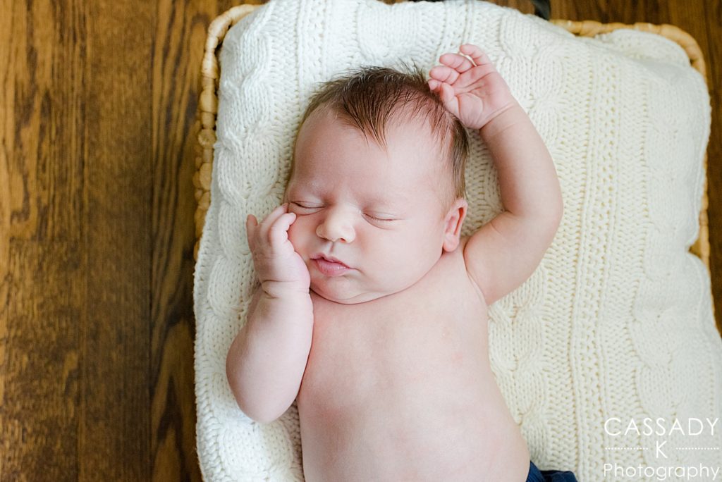 Natural pose of baby boy falling asleep during Bedford newborn picture session in Westchester, NY