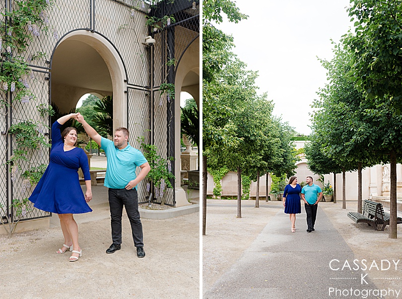 Engaged couple twirling under arch in Longwood Gardens