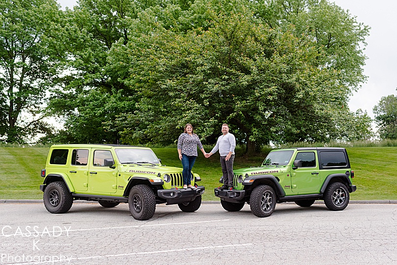 Engaged couple standing on green Jeeps during engagement session at Longwood Gardens