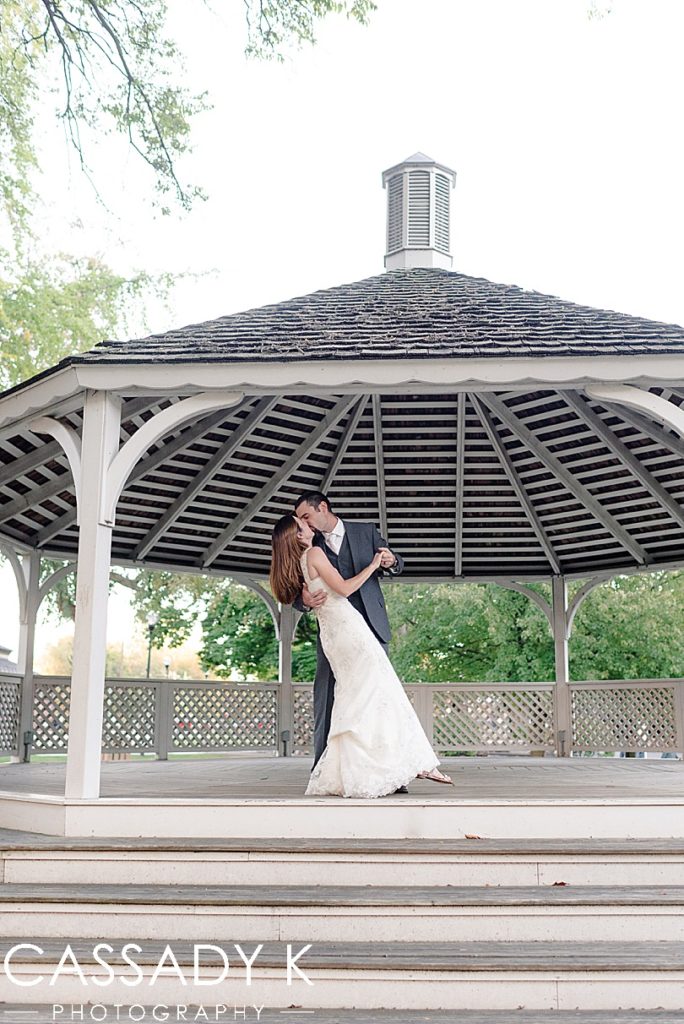 Husband and wife kissing in gazebo during their 5th wedding anniversary photos