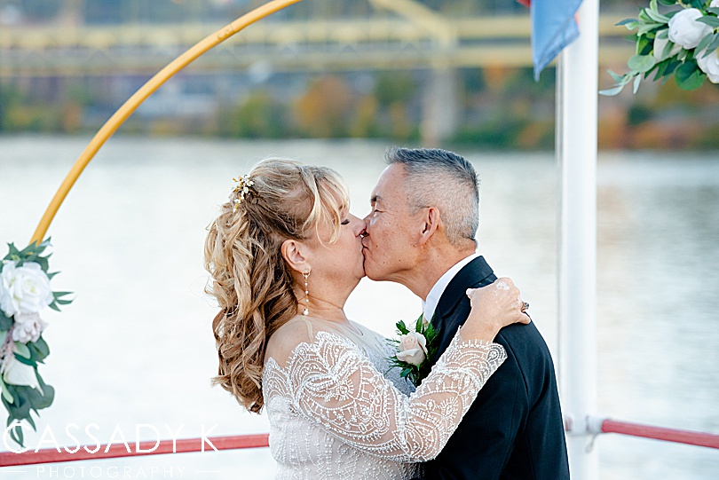 Bride and groom first kiss in City of Bridges for fall Gateway Clipper wedding