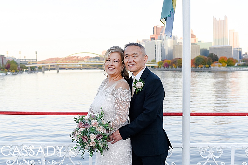 Bride and groom posing in front of bridge during fall Gateway Clipper wedding