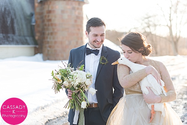 Couple kissing a duck during a Gold Winter Wedding Inspiration Styled Shoot in the Poconos, Pennsylvania for Ignite a free photography workshop