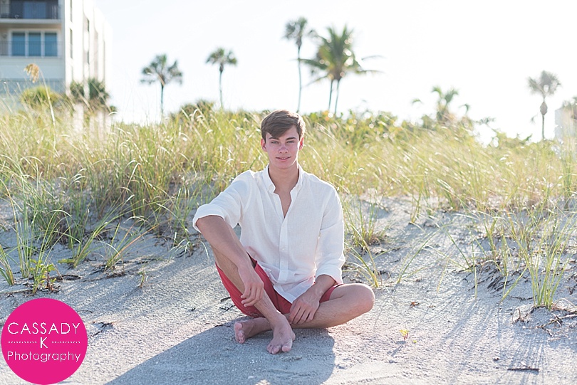 17 Year Old boy sitting in sand dunes for Longboat Key Senior Pictures in Florida