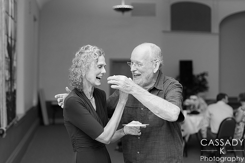 Husband and wife feeding each other cake at their 40th wedding anniversary party