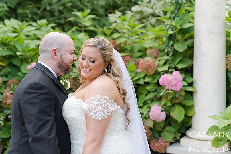 Groom whispers in Brides ear in a intimate garden during a Seasons Catering Wedding in the Township of Washington, NJ