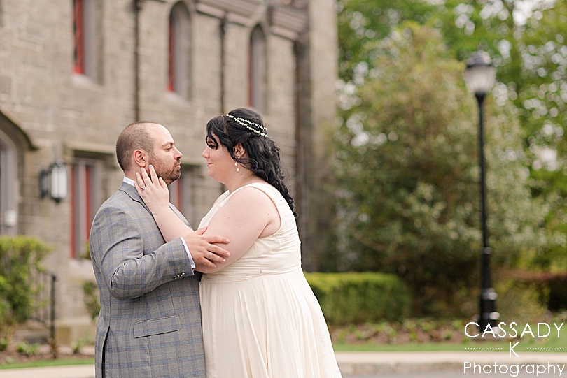 Bride and Groom looking at each other in front of castle during portraits at a Whitby Castle wedding in Rye, NY