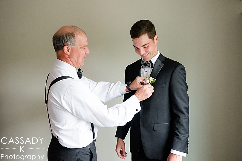 Father helps Groom put on boutonnière for a Small Ninety Acres Wedding in Natirar of Peapack, NJ