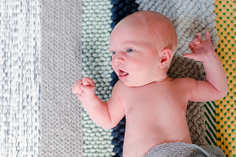 Baby boy with cleft palate lays on Ikea color block, stripe rug in nursery at home Williamsport Newborn Session in PA