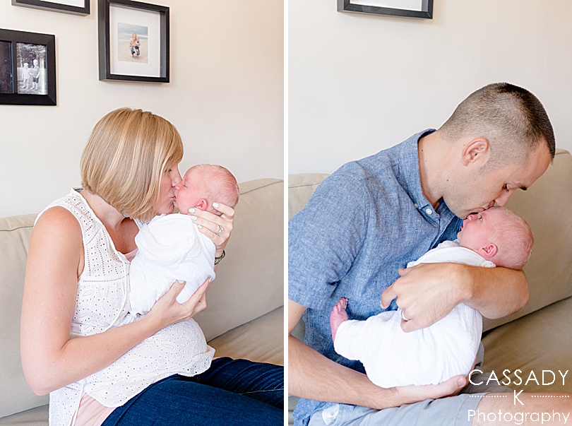 Mom and Dad each hold baby boy and kiss him at home Williamsport Newborn Session in PA