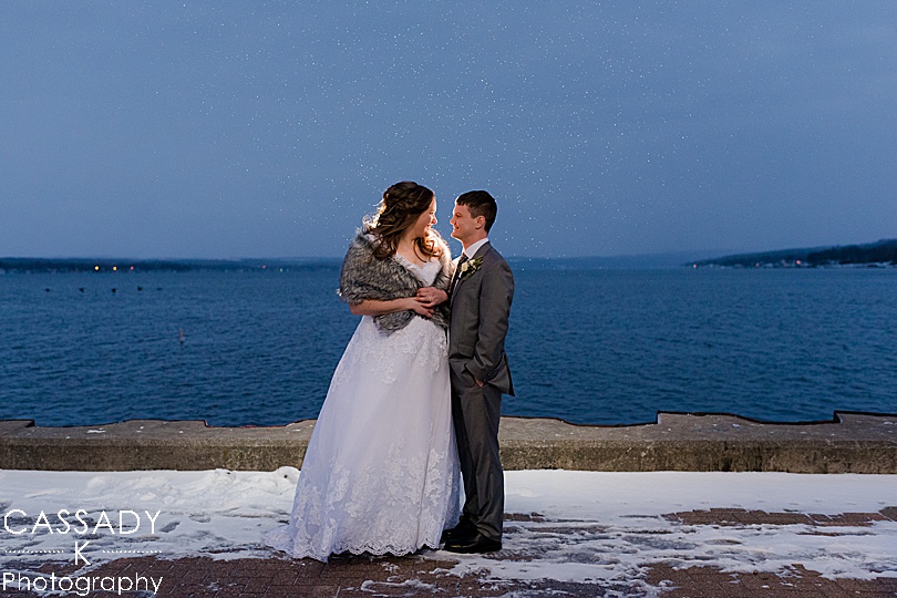 Bride and Groom in the snow in front of lake at Canandaigua City Pier for the 2020 photography review