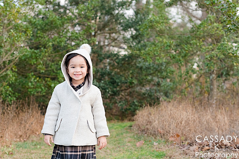 Little girl wears a cute winter coat during holiday portraits at Greenwich Audubon Center in CT for a 2020 photography review