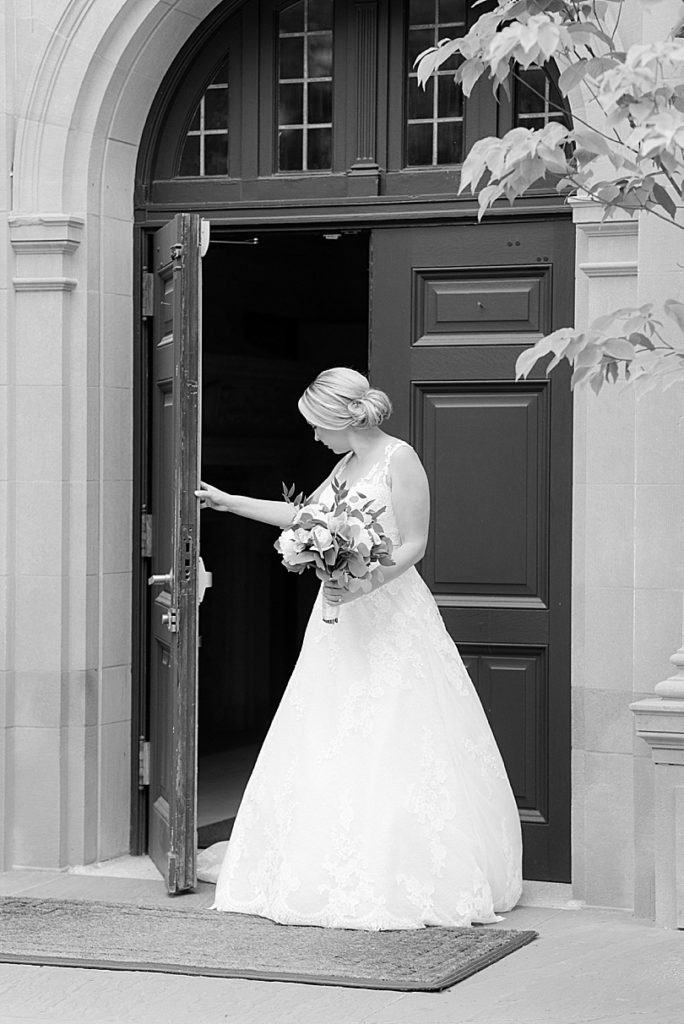 Black and White of bride walking out the front door for a first look for her Mansion at Natirar Wedding in Peakpack, NJ