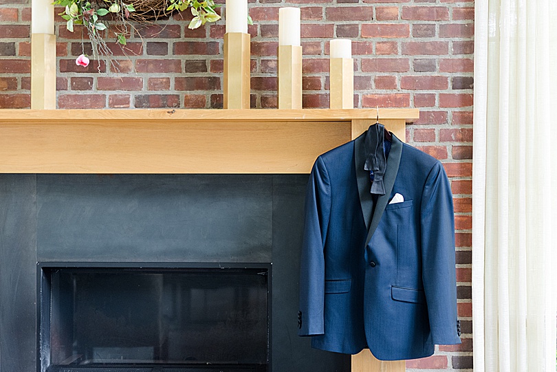 Groom's navy tux hanging on a mantle at Ninety Acres while he got ready for a Mansion at Natirar Wedding in Peakpack