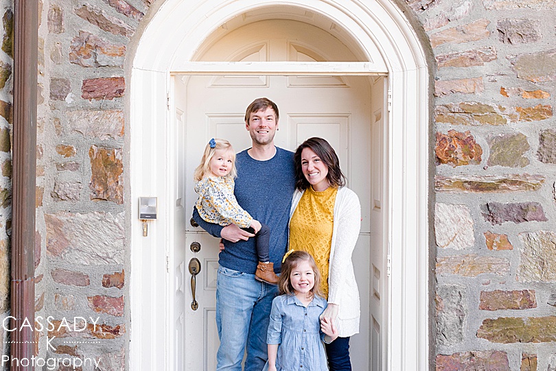 Family of four standing in front of door during Prophecy Creek Park Family Session in Ambler, PA