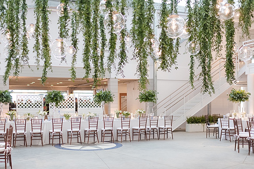 Hanging greenery and glass circle lights strung across the reception area for a spring Tokeneke Club Wedding in Darien, CT