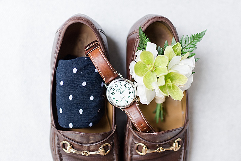 Groom's details with navy polka dot socks, a white and green boutonnière, and brown leather watch for a Tokeneke Club Wedding