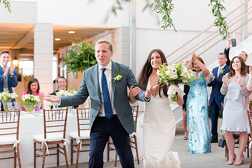 Bride and Groom enter their Tokeneke Club Wedding reception in Darien, CT under the canopy of hanging greenery
