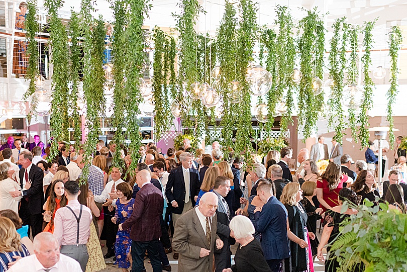 Guests dance under the canopy of hanging greenery at a Tokeneke Club Wedding reception in Darien, CT