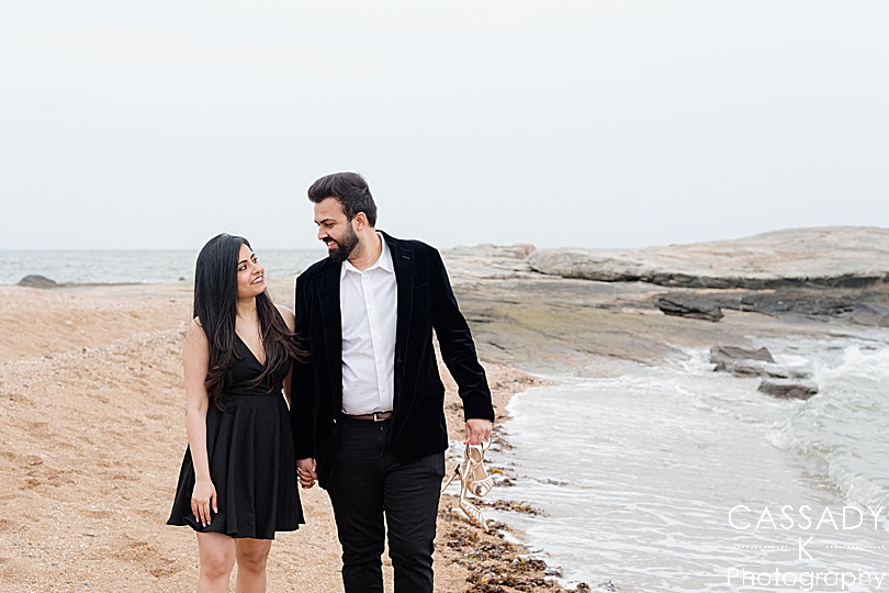 Couple walks along the beach after just getting engaged during a Madison Beach engagement proposal