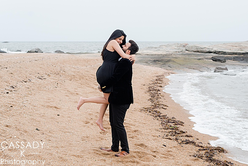 Groom picks up his newly engaged fiancé along the beach after a Madison Beach engagement proposal
