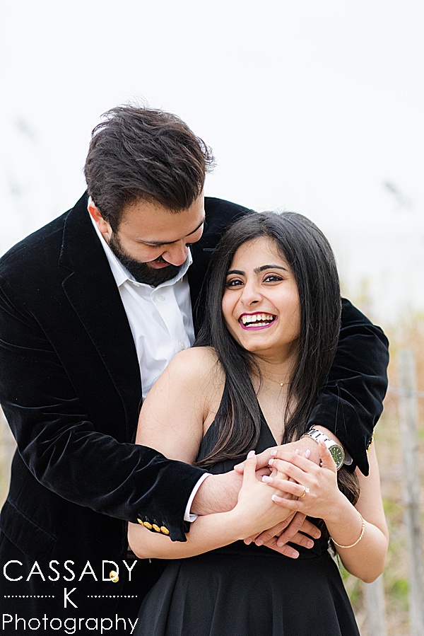 Indian couple's engagement session after just getting engaged waterfront during a Madison Beach engagement proposal