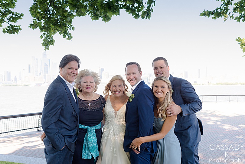 Bride and groom and immediate family picture with NYC skyline and Hudson river for their Antique Loft Hoboken Wedding