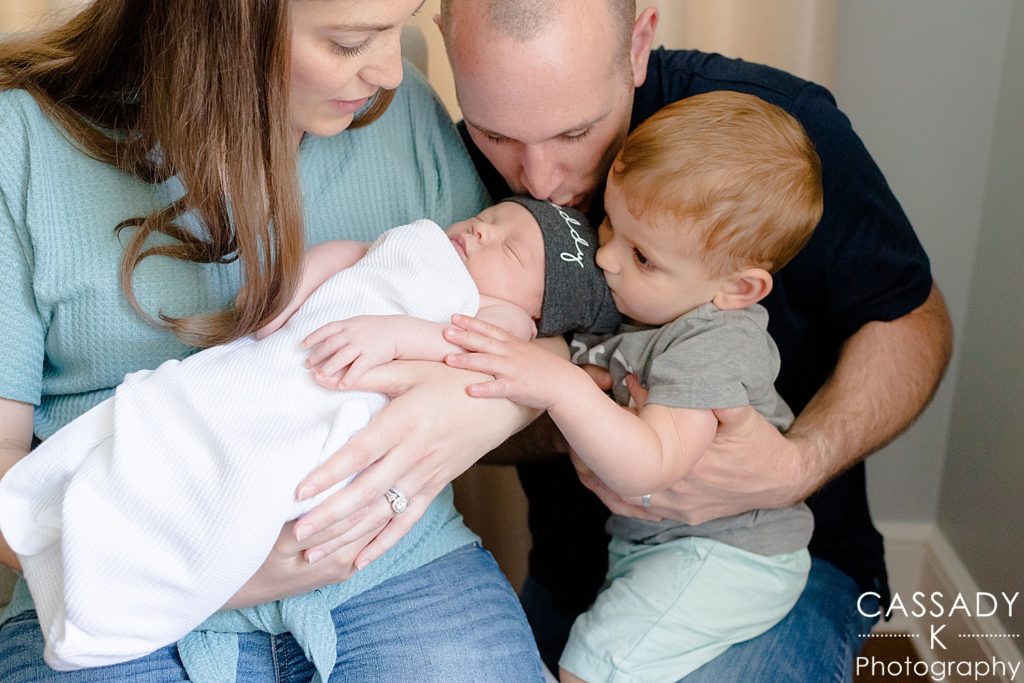 Family with big brother looking at baby during newborn portrait pictures in Westchester County, NY