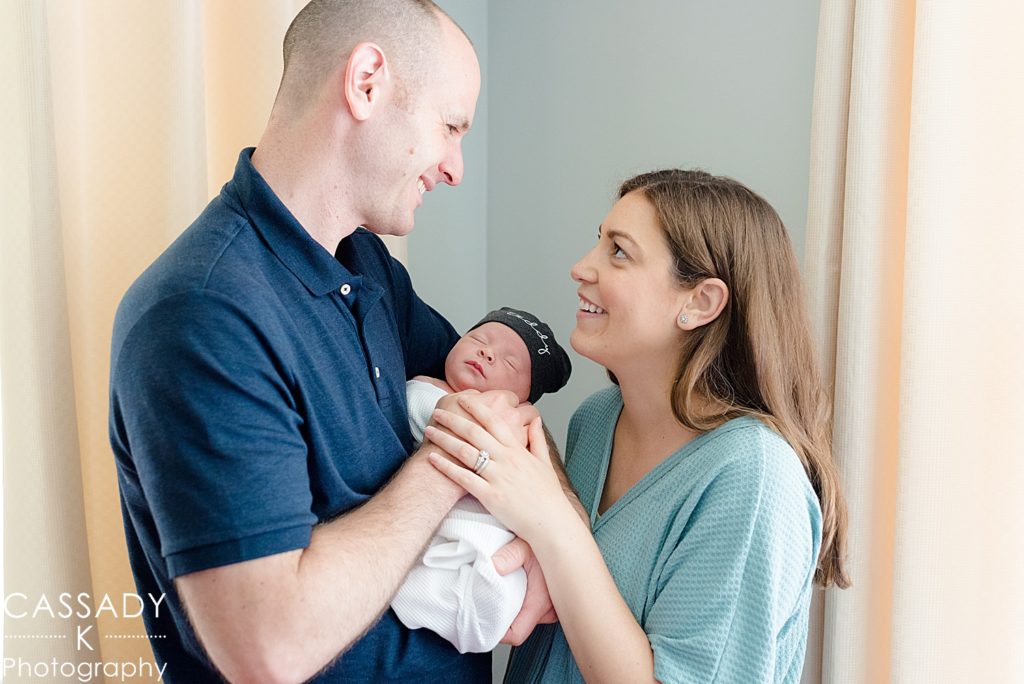 Color image of mother and father holding baby boy during Bedford newborn pictures