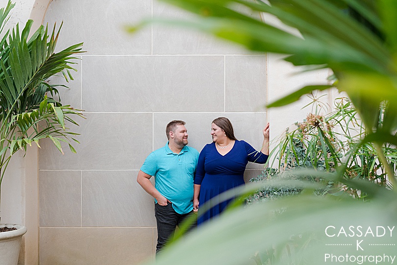 Engaged couple standing by wall in Longwood Gardens Engagement Photos